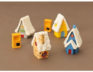 Miniature Christmas house set with snow-capped roofs and yellow postbox ornaments