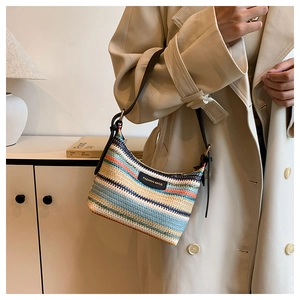 Detail of colorful woven shoulder bag with horizontal stripes and black leather strap
