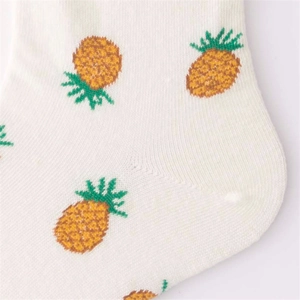 Detail shot of white cotton socks featuring yellow pineapple jacquard knit pattern
