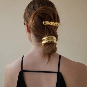 Moderner goldener Metall-Haarclip und Haarreif für einen tiefen Pferdeschwanz