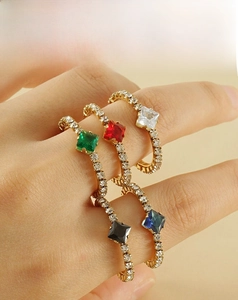 Detail of five 18k gold plated stainless steel rings with colorful square gemstones