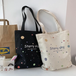 Détail du motif ciel étoilé et de la texture en toile sur les sacs noirs et beige