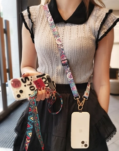 Detailed view of adjustable ethnic woven phone lanyard with metal hooks and plastic buckles
