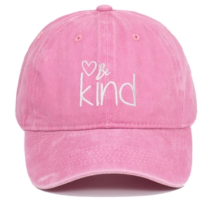 Detailed close-up of Be Kind heart embroidery on vintage washed pink cotton baseball cap