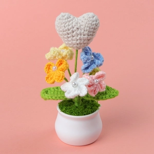 Handmade crochet heart and colorful flowers in a white ceramic pot desk ornament