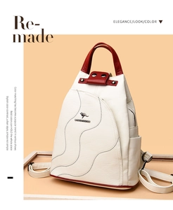 Detail showing red textured handle and kangaroo logo on beige patchwork backpack