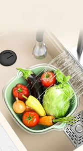 Detail of deep double-layer plastic drain basket with fresh vegetables in a kitchen sink