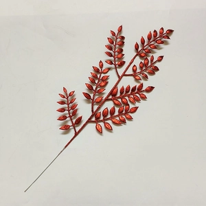 Dettaglio del ramo con foglie di Natale artificiali e finitura glitterata rossa densa