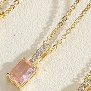 Macro detail of square pink zircon pendant on a 14K gold plated choker necklace