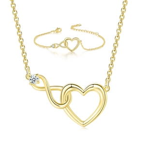 Close-up of golden necklace and bracelet set with hollow heart and infinity crystal charms