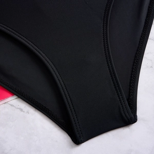 Detailed view of the double-stitched seams and smooth fabric on black bikini bottoms