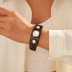 Detail view of a vintage resin cuff bracelet featuring three inset sparkling crystals