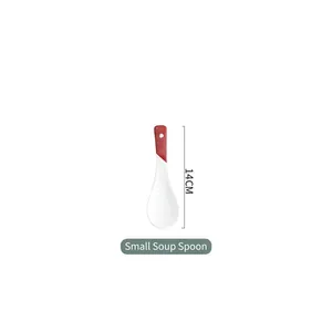 Detail view of a 14cm red and white ceramic spoon with a long handle and hanging hole