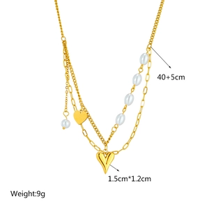 Detail view of double-layer gold chain necklace with heart pendants and white pearls