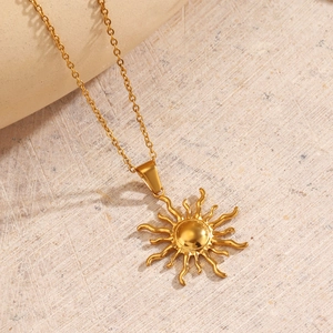 Collier soleil en acier inoxydable plaqué or 18K sur une surface en pierre naturelle