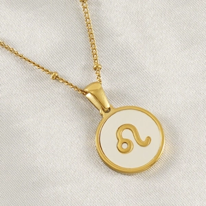 Detailed close-up of 18K gold plated Leo zodiac pendant with white shell background