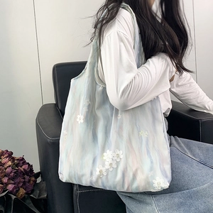 Détail du sac cabas dégradé bleu clair avec fleurs 3D appliquées sur tissu résille