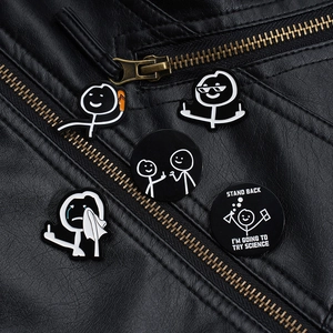 Detail von lustigen Emaille-Anstecknadeln an einer schwarzen Biker-Lederjacke