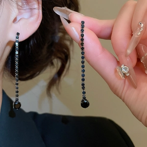 Detail of long black rhinestone drop earrings featuring sparkling silver-tone metal links