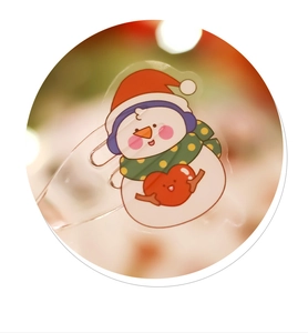 Close-up of cute cartoon snowman acrylic sticker with festive red and white details
