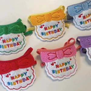 Detail view of colorful plush pet birthday bibs with happy birthday embroidery