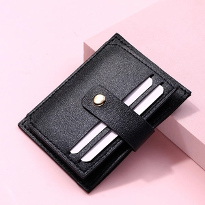 Detail of black litchi grain leather card holder with gold button and multiple card slots