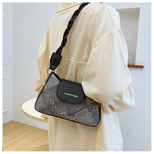 Grey denim shoulder bag with black leather flap and floral chain strap worn by a model