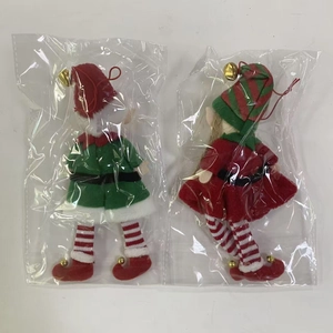 Close-up of plush Christmas elf ornaments in red and green with golden bells