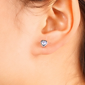 Macro shot of heart-shaped silver stud earring with sparkling clear cubic zirconia