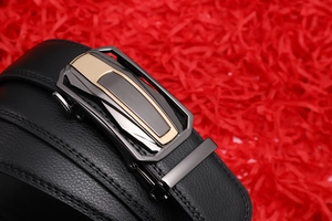 Detail of black leather belt with lychee texture and two-tone automatic metal buckle