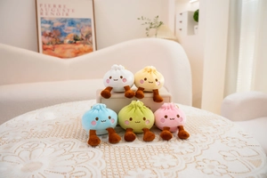 Close-up of five colorful steamed bun plush pendants with cute legs and faces