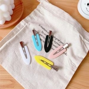 Set of 5 colorful seamless hair clips in pastel tones on a linen bag and wood surface