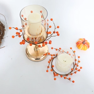 Detail eines herbstlichen Kerzenhalters mit Goldfuß, Glaszylinder und Beerenringen