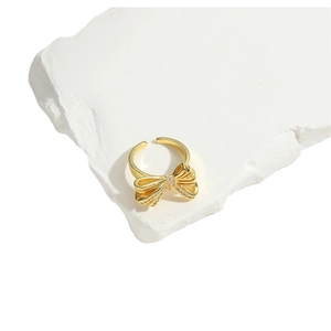 Luxury open bow ring in gold finish with sparkling crystals on white marble stone