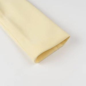 Detailed close-up of light yellow wool coat cuff with clean stitching and premium texture