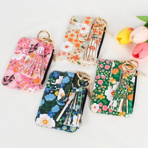 Flat lay of floral pattern card holders with decorative tassels and golden metal keyrings