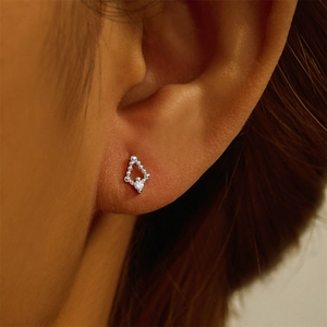 Close-up of S925 sterling silver diamond-shaped earring with zircon on a model