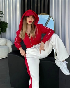 Détail de la veste à capuche et du pantalon large à rayures en rouge et blanc
