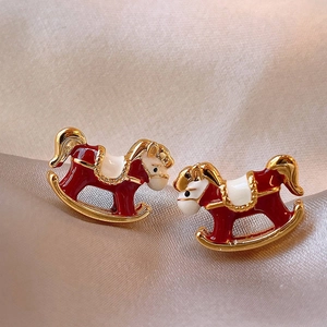 Boucles d'oreilles cheval à bascule doré et émail rouge sur satin champagne
