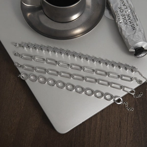 Close-up of diverse silver stainless steel paperclip and star chains on a desk