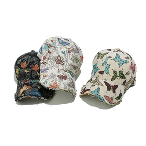 Embroidered butterfly baseball cap with frayed brim detail and colorful jacquard patterns