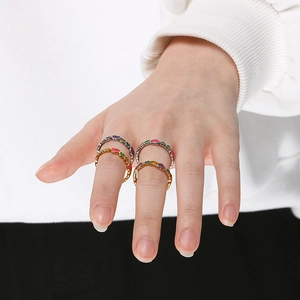 Close-up of colorful heart drip oil rings worn by a model in gold and silver finish