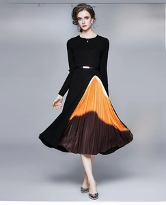 Détail d'une robe en tricot à manches longues avec jupe plissée en dégradé et ceinture