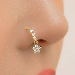 Golden flower nose ring with crystals and pendant shown on model in a professional close-up