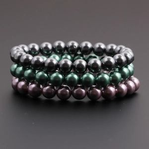 Vue détaillée de bracelets à triple rangée en perles grises, vert foncé et violettes polies