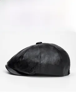 Side view of black faux leather newsboy cap showing textured finish and structured brim