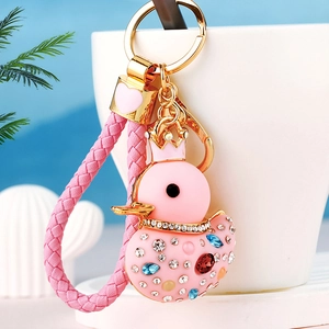 Detail of pink crystal duck keychain with gold crown and woven strap accessory