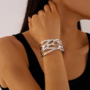 Macro detail of silver layered wide cuff bracelet showing a polished woven metal design