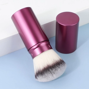 Detail of portable telescopic makeup brush with purple metal case and soft dual-tone bristles