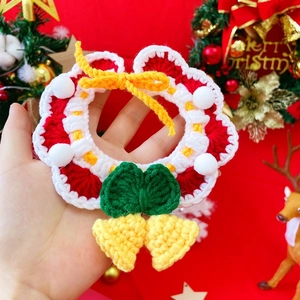 Detailed macro of handmade crochet Christmas wreath collar for cats and dogs with a bell